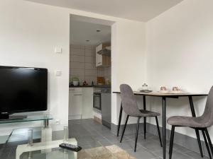 a kitchen with a table and two chairs and a television at Ferienwohnung Rosenweg in Schmalkalden
