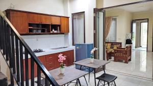 uma cozinha e sala de estar com mesa e cadeiras em Atmosfer Guest House Sentul em Bogor