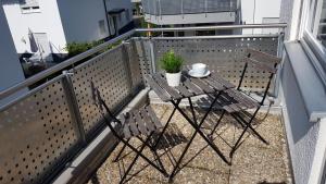 a table and two chairs on a balcony at Ferien- und Businessapartment I Modern mit WLAN und Parkplatz nahe Zentrum, Automobil- und Tech-Firmen, Messe in Renningen