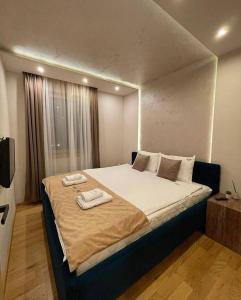 ein Schlafzimmer mit einem großen Bett mit zwei Handtüchern darauf in der Unterkunft Apartman Onore 2 in Zlatibor