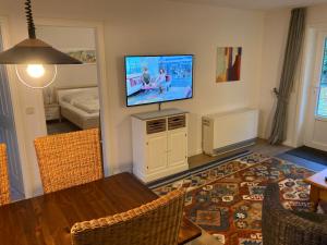 sala de estar con TV de pantalla plana en la pared en Bungalow 1, en Wyk auf Föhr