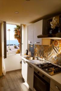 a kitchen with a sink and a view of the ocean at Tuffonelblu in Ventimiglia