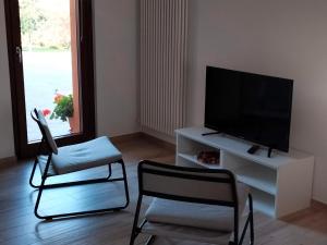 uma sala de estar com 2 cadeiras e uma televisão de ecrã plano em B&B La Casa di Giuliana em Cermignano