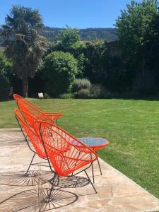 two orange chairs and a glass table on a patio at My Pod House in Esquel