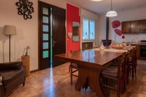 a kitchen and dining room with a wooden table and chairs at Al Casale B&B in Casalserugo