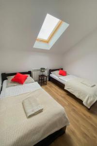 sypialnia z 2 łóżkami i czerwonymi poduszkami w obiekcie Apartament Bieszczady w mieście Hoczew