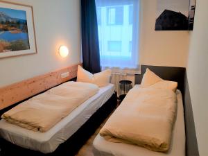 2 camas en una habitación pequeña con ventana en Appartement Hohe Tauern & Großvenediger, en Mittersill