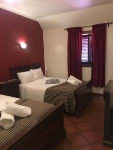 Una habitación de hotel con dos camas y una ventana. en Alojamento de montanha, en Penhas da Saúde