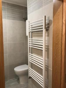 Un baño con inodoro y dispensador de papel higiénico. en Alojamento de montanha, en Penhas da Saúde