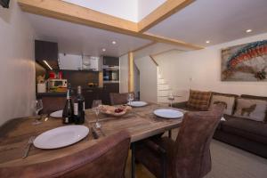 a dining room and kitchen with a table and chairs at Résidence Grand Roc - Bruyères 022 - Happy Rentals in Chamonix