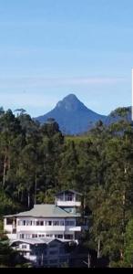 a large white house in the middle of a mountain at Tea Hills Bungalow in Hatton