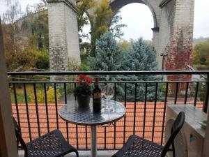 庫尼奧的住宿－La petite maison de Claire，阳台上的桌子上摆放着一瓶葡萄酒和玻璃杯