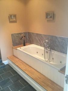 a bath tub in a bathroom with at Belton House Holiday Home in Wanlockhead +32 photos