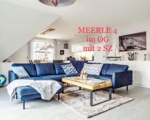 ein Wohnzimmer mit einem blauen Sofa und einem Tisch in der Unterkunft Haus MEERLE in Zingst