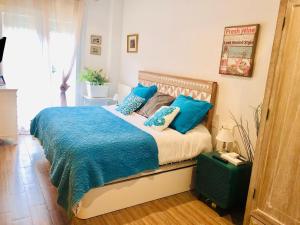 a bedroom with a large bed with blue pillows at Cozy apartment in Ampuero