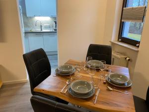 una mesa de madera con platos y copas de vino. en Ferienwohnung Rodachaue, en Bad Rodach