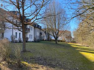 ein großes weißes Haus mit Bäumen im Hof in der Unterkunft Ferienwohnung Rodachaue in Bad Rodach