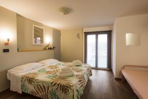 una camera da letto con un letto e asciugamani di Hotel Paris a Rimini