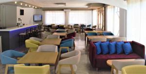 a restaurant with many tables and chairs and couches at Apollon Hotel in Agios Nikolaos