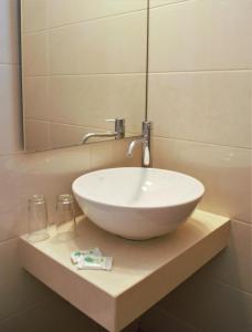 a white bowl sink on a counter in a bathroom at Apollon Hotel in Agios Nikolaos