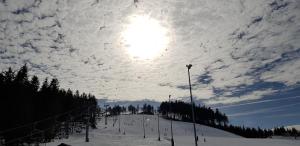 阿貝爾塔米的住宿－Apartmány Plešivec，雪覆盖的滑雪场上空的云天