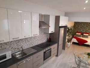 a kitchen with white cabinets and a sink at APARTAMENTO LA CRUCILLADA in La Guancha