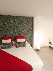 a bedroom with a large white bed with red pillows at APARTAMENTO LA CRUCILLADA in La Guancha