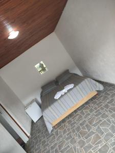Dormitorio pequeño con cama en el ático en Pousada e restaurante Além das Nuvens en Guaratinguetá