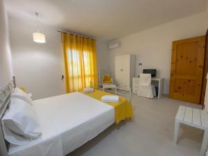 a bedroom with a large white bed and a desk at Villa Vistasalentina Piano terra in Torre Colimena