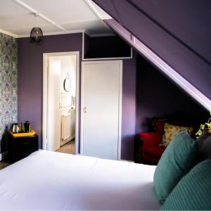 a bedroom with a bed and a purple wall at The Residence at Bolenna in Perranporth