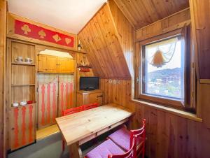 una sala da pranzo con tavolo in legno e finestra di Appartamento Il Riccio Terminillo a Terminillo