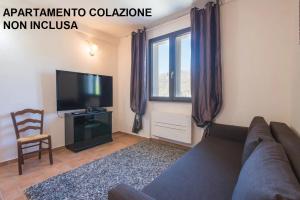 ein Wohnzimmer mit einem Sofa und einem Flachbild-TV in der Unterkunft Locanda San Marino Al Coppo in Monte Grimano Terme