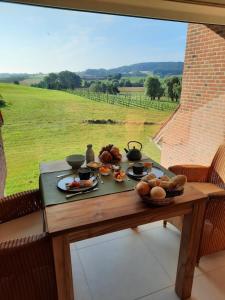 uma mesa com comida com vista para um campo em B&B De Zavelaar em Heuvelland