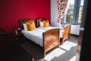 a bedroom with a bed with orange pillows on it at The Godwins in Hereford