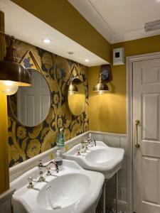 a bathroom with two sinks and a mirror at The Wellington Hotel in Ventnor +37 photos