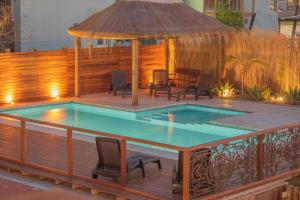 a pool on a deck with chairs and a gazebo at Muelles del Diablo Tranquilo in Punta Del Diablo