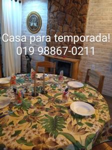 a table with a table cloth on it with plates on it at Casa Recanto Beija Flor, Monte Verde in Monte Verde
