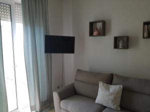 a living room with a couch and a flat screen tv at Kennedy House in Novoli