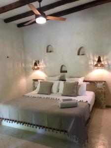 a bedroom with a large bed with a ceiling fan at VerdeAmar Eco Lodge Jungle Retreat in Chemuyil