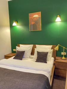 ノヴォクズネツクにあるHotel G.S.の緑の壁のベッドルーム1室(大型ベッド1台付)