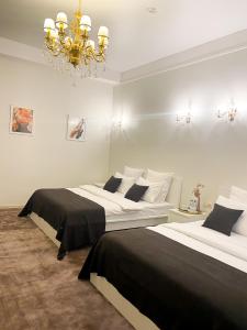 a bedroom with two beds and a chandelier at Hotel G.S. in Novokuznetsk