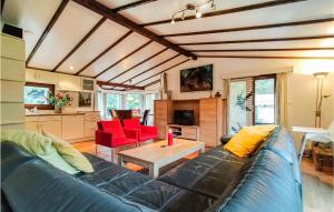 - un salon avec un canapé bleu et des fauteuils rouges dans l'établissement Beautiful Home In Sint-annaland With Sauna, à Sint-Annaland