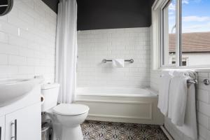 un bagno bianco con vasca e WC di Gougane Barra Hotel a Ballingeary