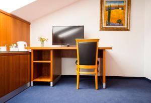 an office with a desk with a television and a chair at Pension Freiraum Guesthouse Berlin in Berlin