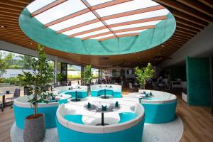普吉市的住宿－HOMA Phuket Town，餐厅设有蓝色和白色的桌子以及玻璃天花板