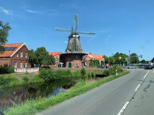 維斯莫爾的住宿－Ferienwohnung -Kiek rin- Wiesmoor Ostfriesland，路边路边的风车