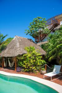a resort with a straw hut and a swimming pool at Holbox Deluxe Apartments in Holbox Island