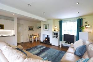 a living room with a white couch and a television at Northumberland-Hideaways in Kielder