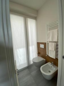 a bathroom with a white toilet and a sink at ToSuite - Alba Moretta in Alba