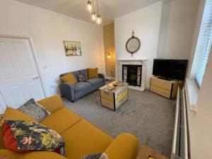 a living room with a couch and a television at Beautiful Georgian Duplex in Gloucester